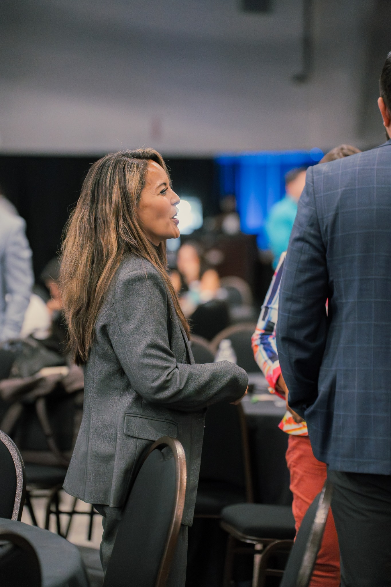 A businesswoman networking with attendees at a professional summit.