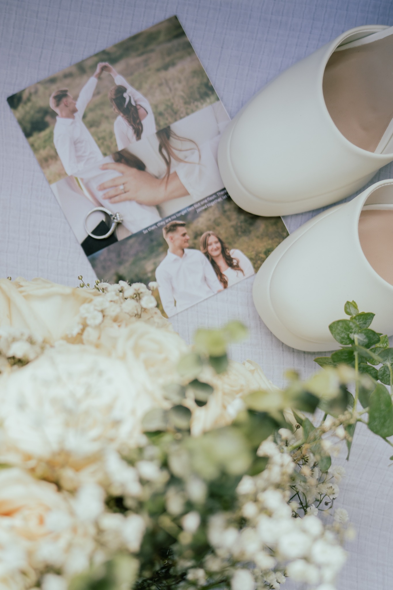 Wedding shoes, rings, invitations, and a white bouquet arranged as a bridal flat lay.