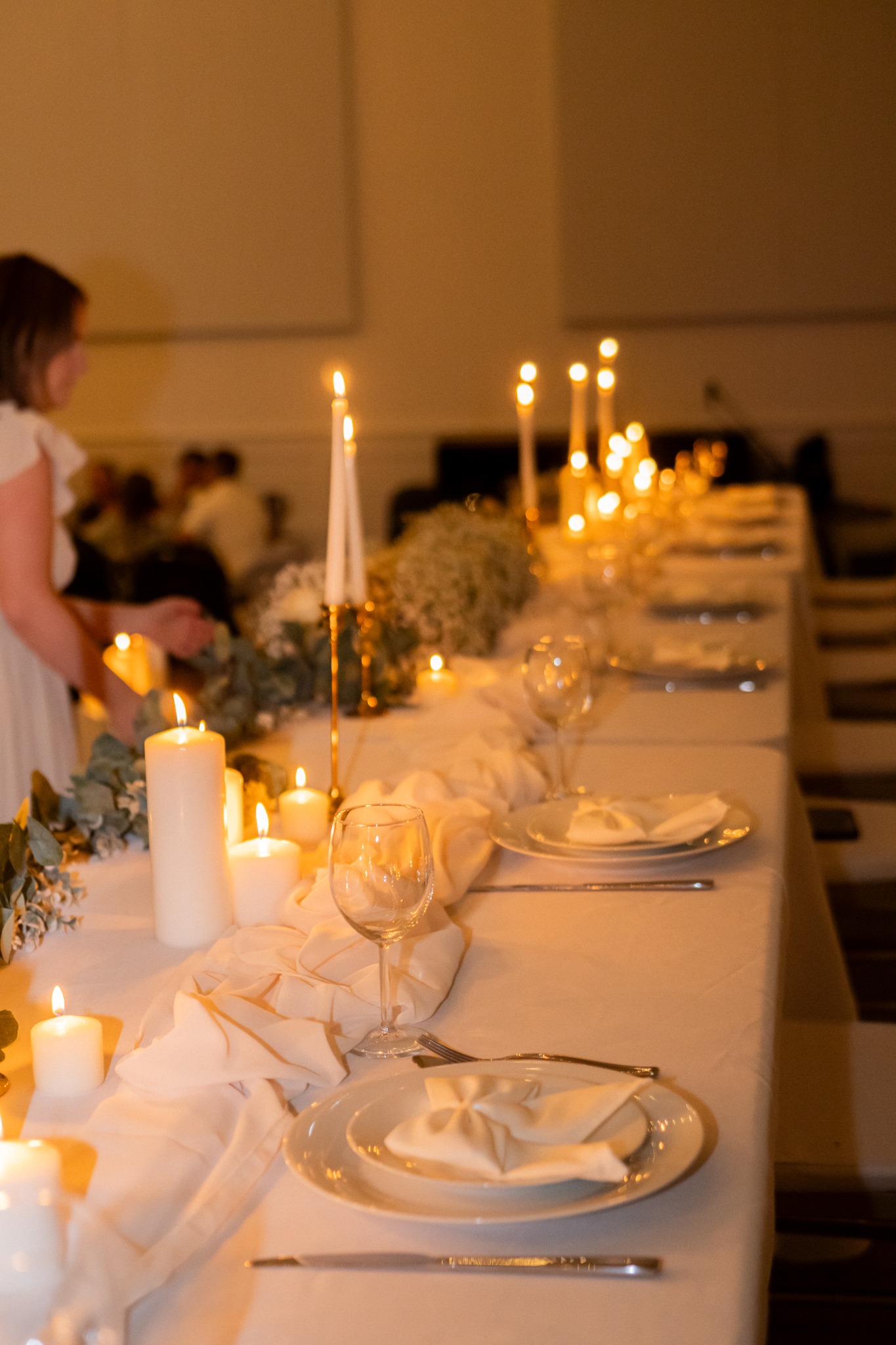 A candlelit wedding reception table glowing after dark.